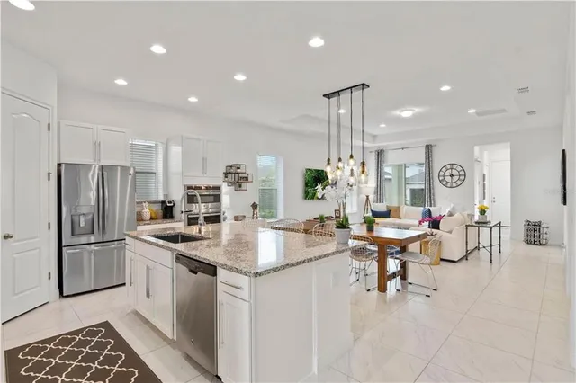 a kitchen with sink refrigerator and dining table