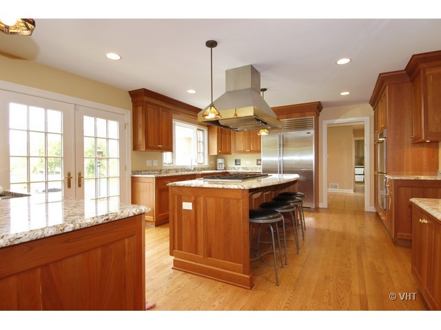 1742 Appleby Road Inverness, IL 60067 - Photo 5 of 25 a kitchen with stainless steel appliances kitchen island granite countertop a refrigerator a sink a stove and a wooden cabinets