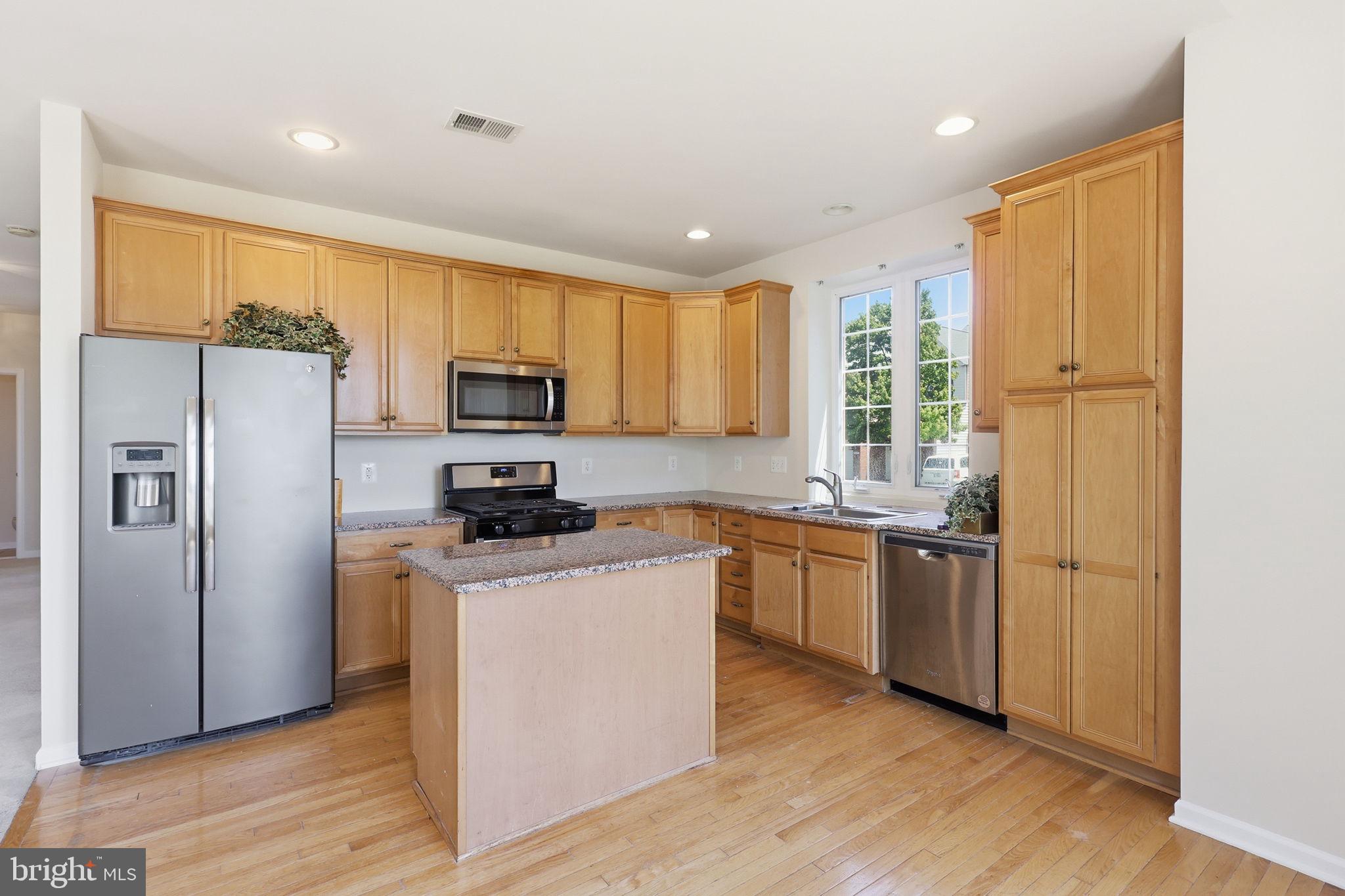 19617 Edgemont Square Ashburn, VA 20147 - Photo 22 of 65 a kitchen with stainless steel appliances granite countertop a refrigerator a stove top oven a sink and dishwasher with wooden floor