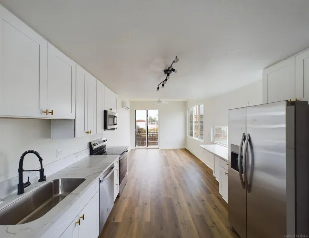 a kitchen with stainless steel appliances a refrigerator sink and cabinets