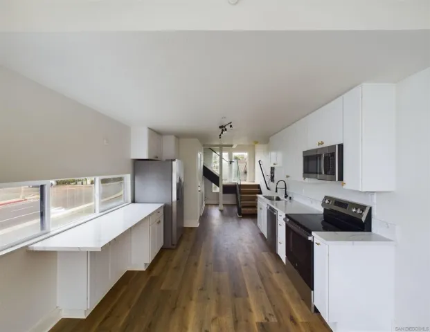 a kitchen with sink stove and refrigerator