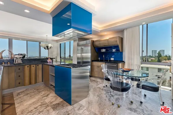 a kitchen with stainless steel appliances kitchen island granite countertop a sink and a counter top space