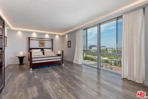 a bedroom with furniture and a large window