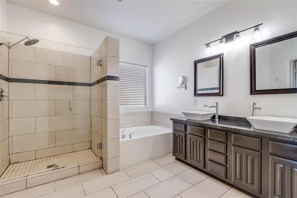 a bathroom with a double vanity sink a toilet a mirror and shower