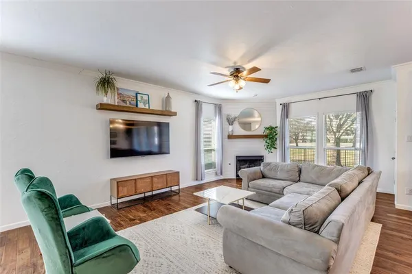 a living room with furniture a flat screen tv and a fireplace