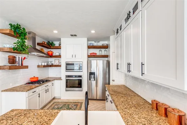 a kitchen with stainless steel appliances granite countertop a refrigerator and a sink