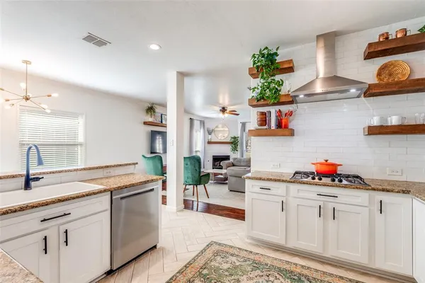 a kitchen with white cabinets and chandelier