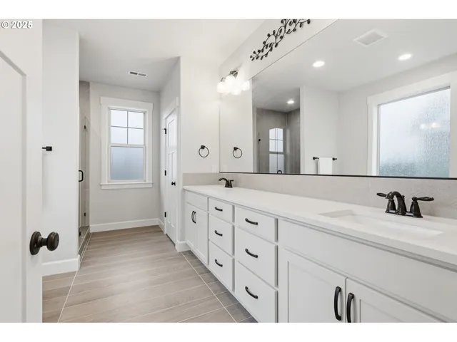 a bathroom with double vanity sink and mirror