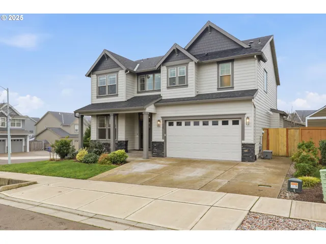 a view of a white house with a large windows and a yard