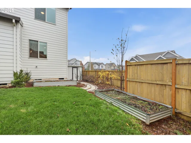 a view of backyard with wooden fence