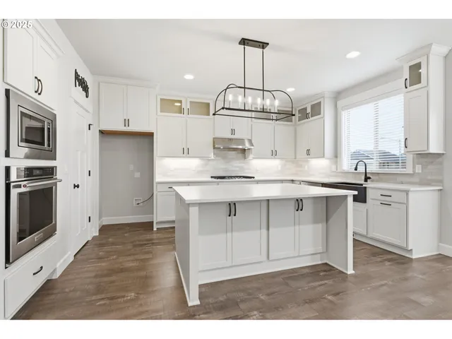 a kitchen with kitchen island granite countertop stainless steel appliances a sink stove and refrigerator