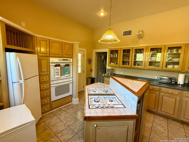 a kitchen with stainless steel appliances granite countertop a refrigerator and a stove