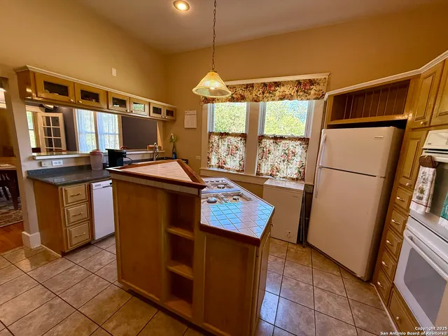 a kitchen with stainless steel appliances granite countertop a refrigerator a sink and a stove