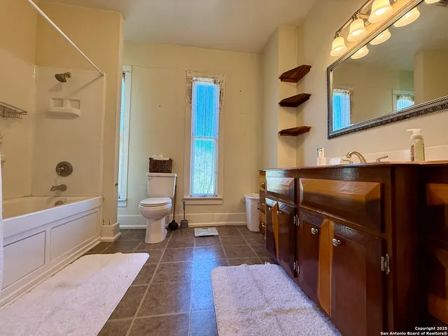 a large bathroom with a sink a toilet and shower