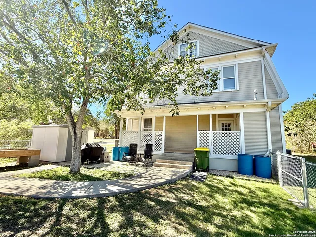 a backyard of a house with fire pit and chairs