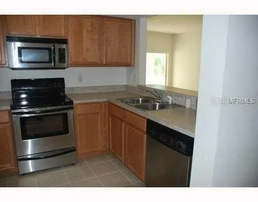 a kitchen with granite countertop stainless steel appliances a stove microwave and sink