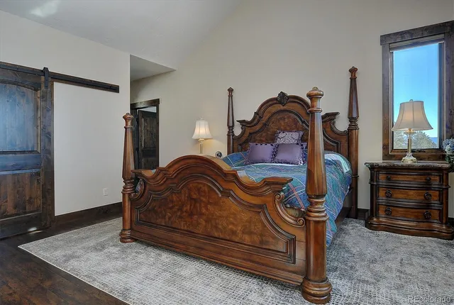 a bedroom with a bed and a mirror on the dresser
