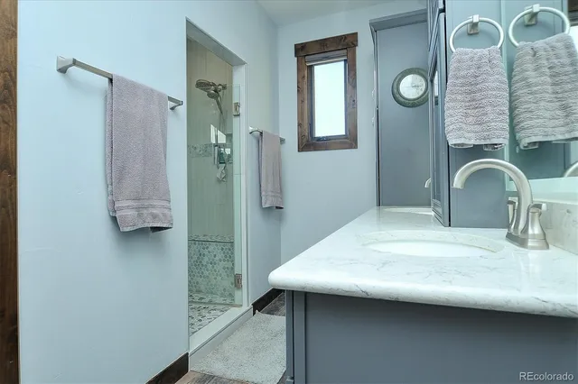 a bathroom with a granite countertop sink and a mirror