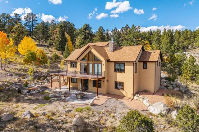 a view of a white house with a yard covered with snow in the background