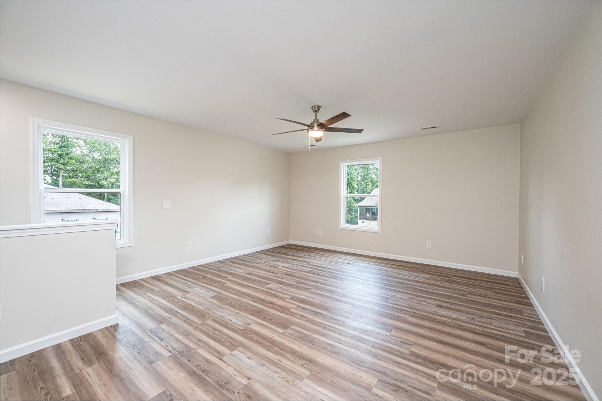 1214 Winter Place Lenoir, NC 28645 - Photo 12 of 19 an empty room with wooden floor chandelier fan and windows