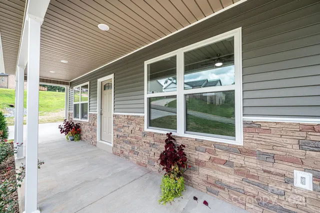 a front view of a house with large windows and potted plants