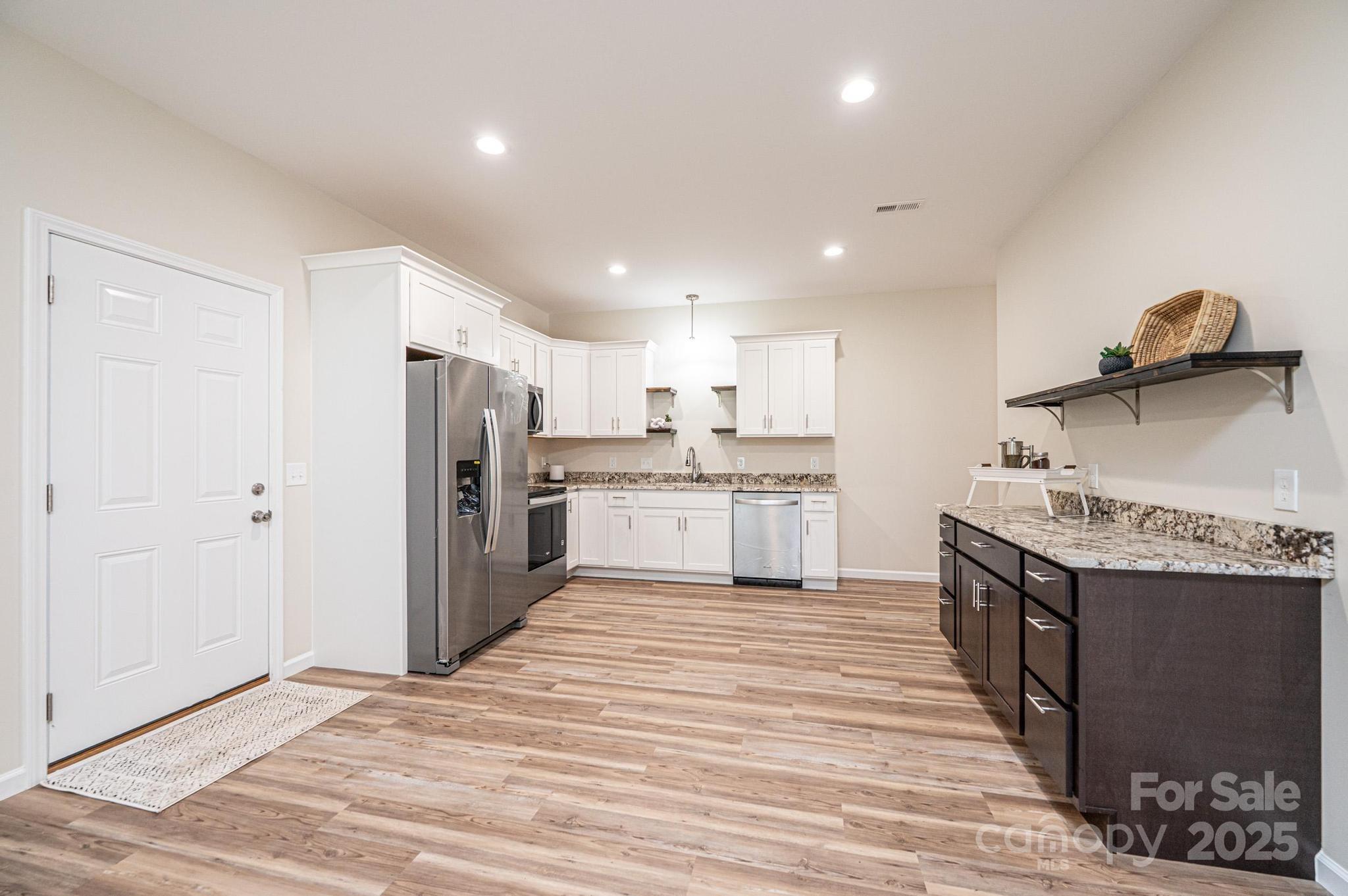 1214 Winter Place Lenoir, NC 28645 - Photo 5 of 19 a kitchen with stainless steel appliances granite countertop a stove top oven a sink and a refrigerator
