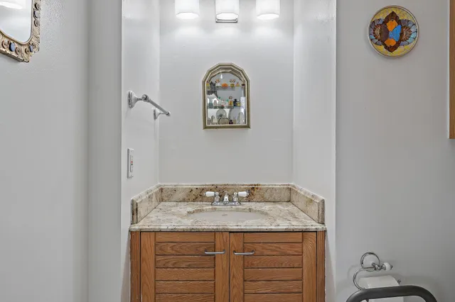 a bathroom with a granite countertop sink and a mirror