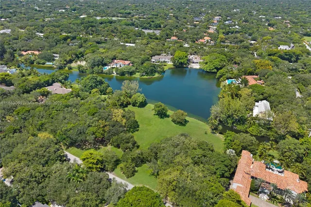 an aerial view of residential house with outdoor space and trees all around