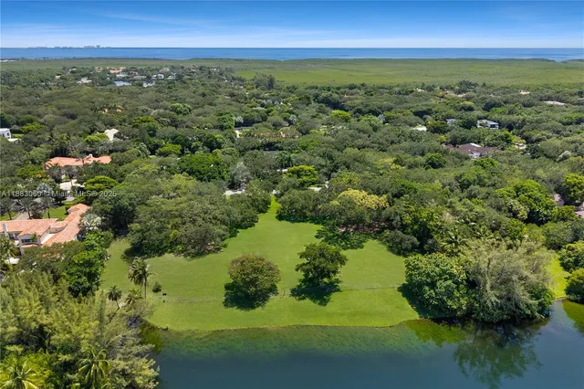 an aerial view of residential houses with outdoor space and lake view