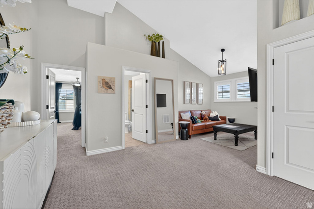14738 Tangle Hill Road Herriman, UT 84096 - Photo 33 of 66 Spacious common area featuring vaulted ceilings, plush carpet flooring, and abundant natural light from dual windows with plantation shutters