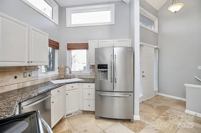 a kitchen with a refrigerator sink and cabinets