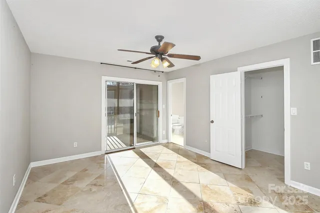 a view of a livingroom with a chandelier fan and windows