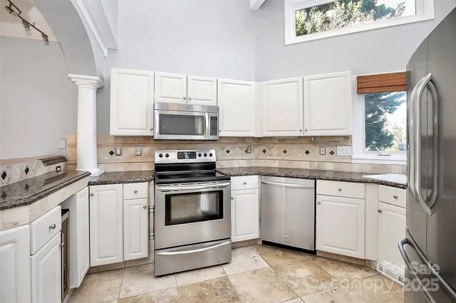 a kitchen with granite countertop white cabinets and white appliances