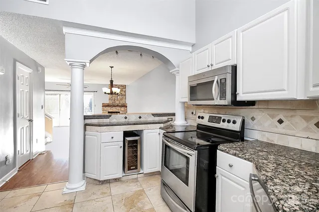 a kitchen with stainless steel appliances granite countertop a stove and a microwave