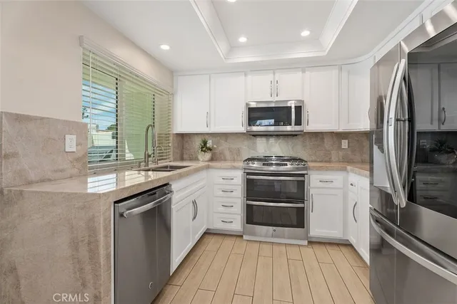 a kitchen with stainless steel appliances a refrigerator sink and microwave