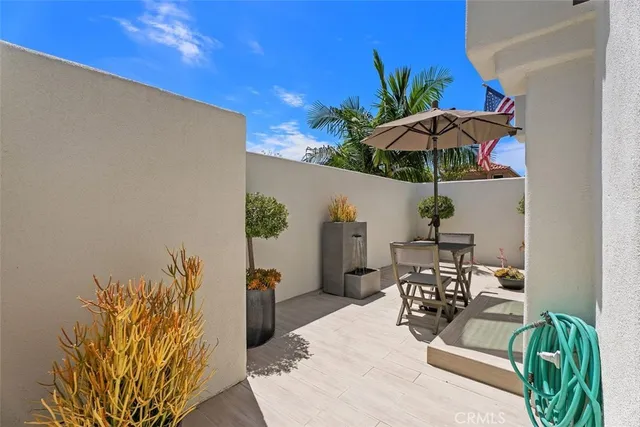a view of a patio with table and chairs under an umbrella