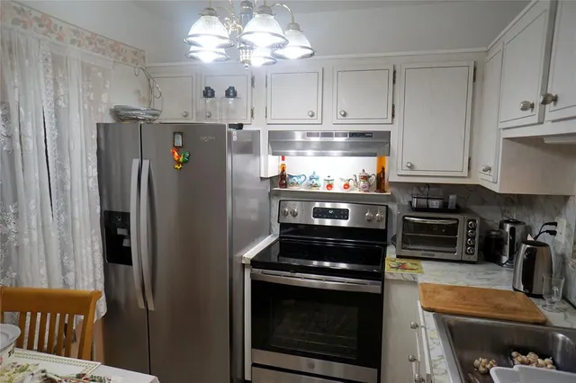 a kitchen with stainless steel appliances granite countertop a refrigerator and a stove top oven