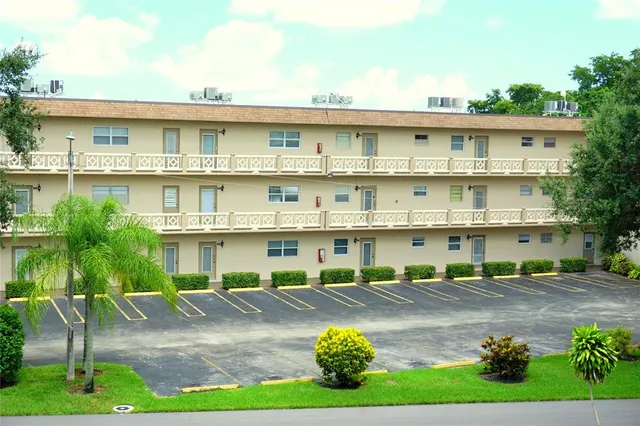 a view of a building with a yard and sitting area