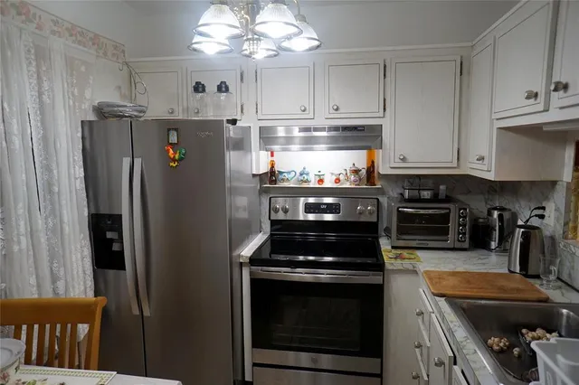 a kitchen with stainless steel appliances granite countertop a refrigerator a stove a sink and dishwasher
