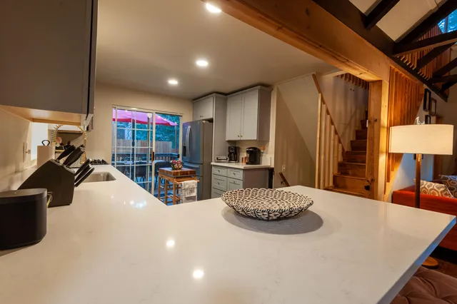 a kitchen with stainless steel appliances kitchen island granite countertop a refrigerator and a sink