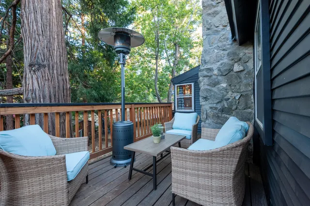 a balcony with wooden floor table and chairs
