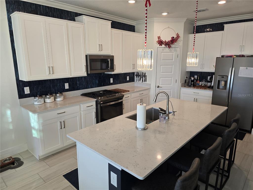 8280 Rolling Tides Drive New Port Richey, FL 34655 - Photo 11 of 49 a kitchen with stainless steel appliances a table chairs and a refrigerator