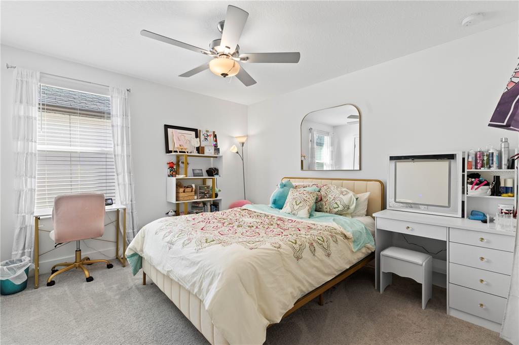 8280 Rolling Tides Drive New Port Richey, FL 34655 - Photo 31 of 49 a bedroom with a bed and a chandelier