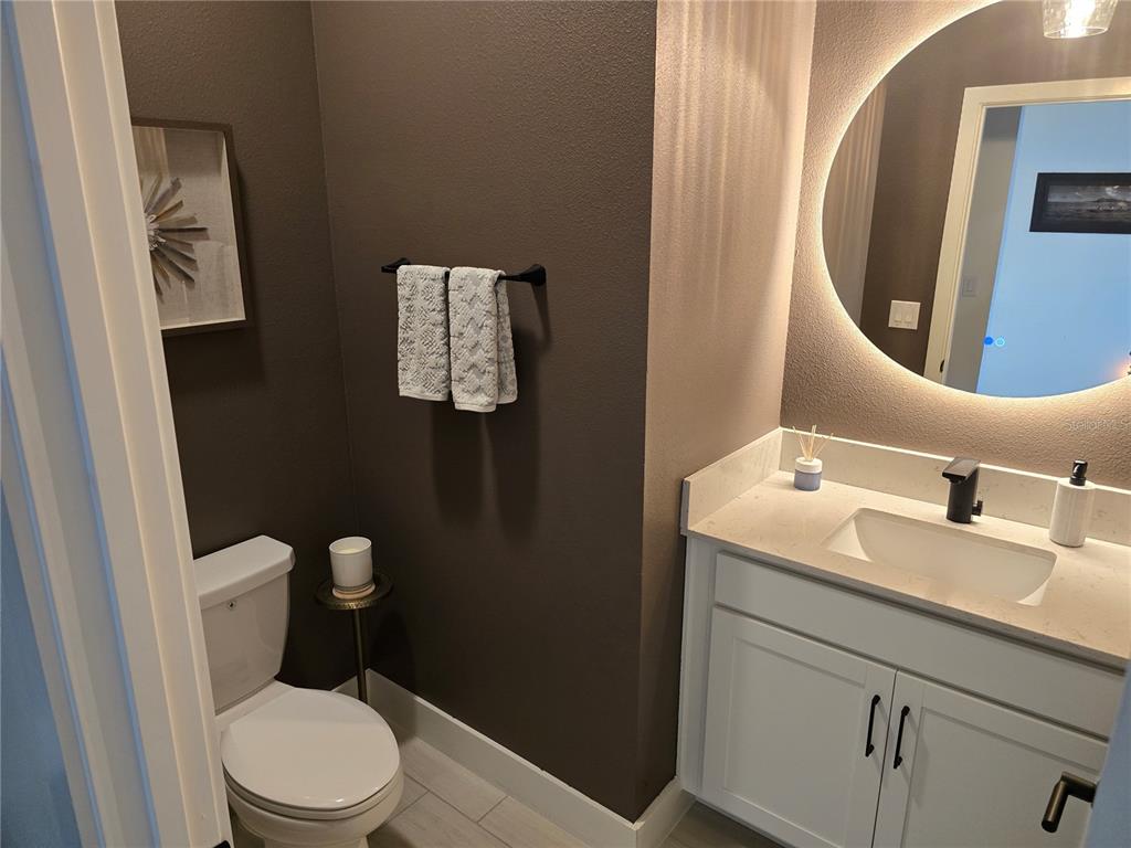8280 Rolling Tides Drive New Port Richey, FL 34655 - Photo 10 of 49 a bathroom with a toilet sink vanity and mirror