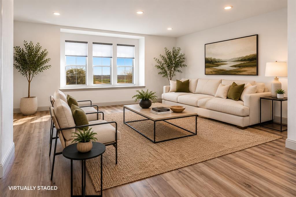 421 Matchbox Street Argyle, TX 76226 - Photo 9 of 40 Spacious living area featuring three large windows, recessed lighting, wood-finish flooring, white walls, and a window sill