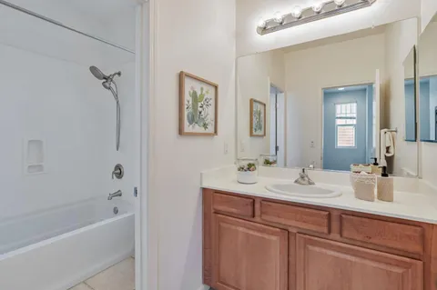 a bathroom with a tub sink and mirror