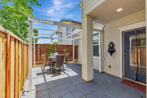 a view of a patio with table and chairs and potted plants