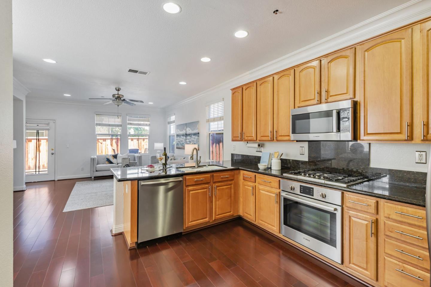 8940 Acorn Way Gilroy, CA 95020 - Photo 18 of 20 a kitchen with stainless steel appliances granite countertop wooden cabinets and a stove top oven