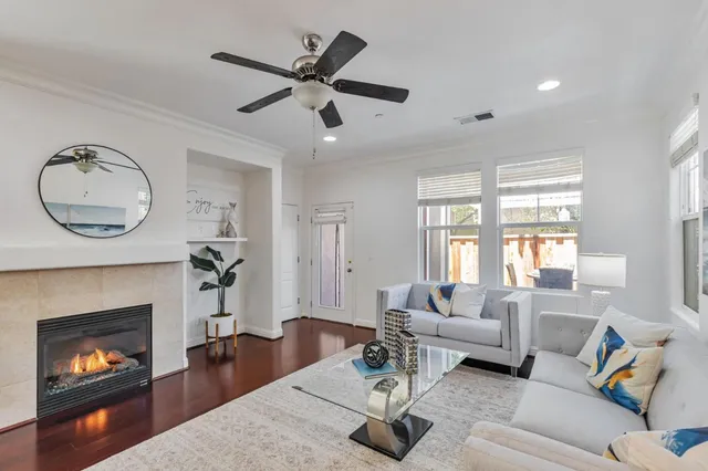 a living room with furniture a fireplace and a large window