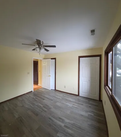 a view of a livingroom with a ceiling fan window and wooden floor